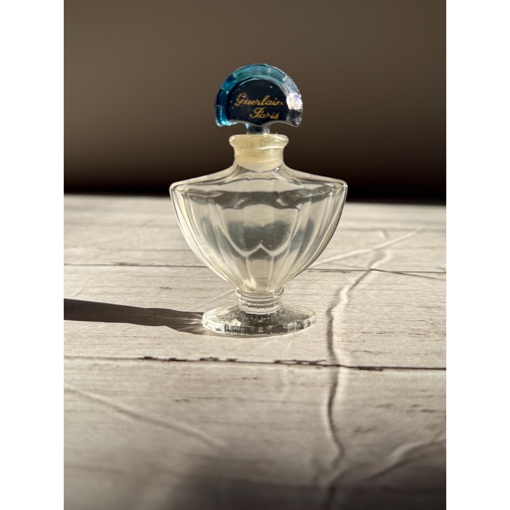 Vintage Guerlain Shalimar crystal perfume bottle with blue stopper.